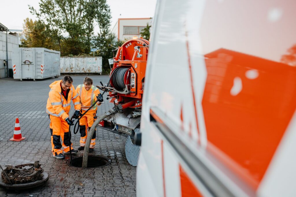 „AQUA-TOOL Team bei einer TV-Inspektion in Melsdorf: Zwei Fachkräfte führen eine Kamerabefahrung im Schacht durch – moderne Kanalinspektion für präzise Diagnosen und sichere Planung.“